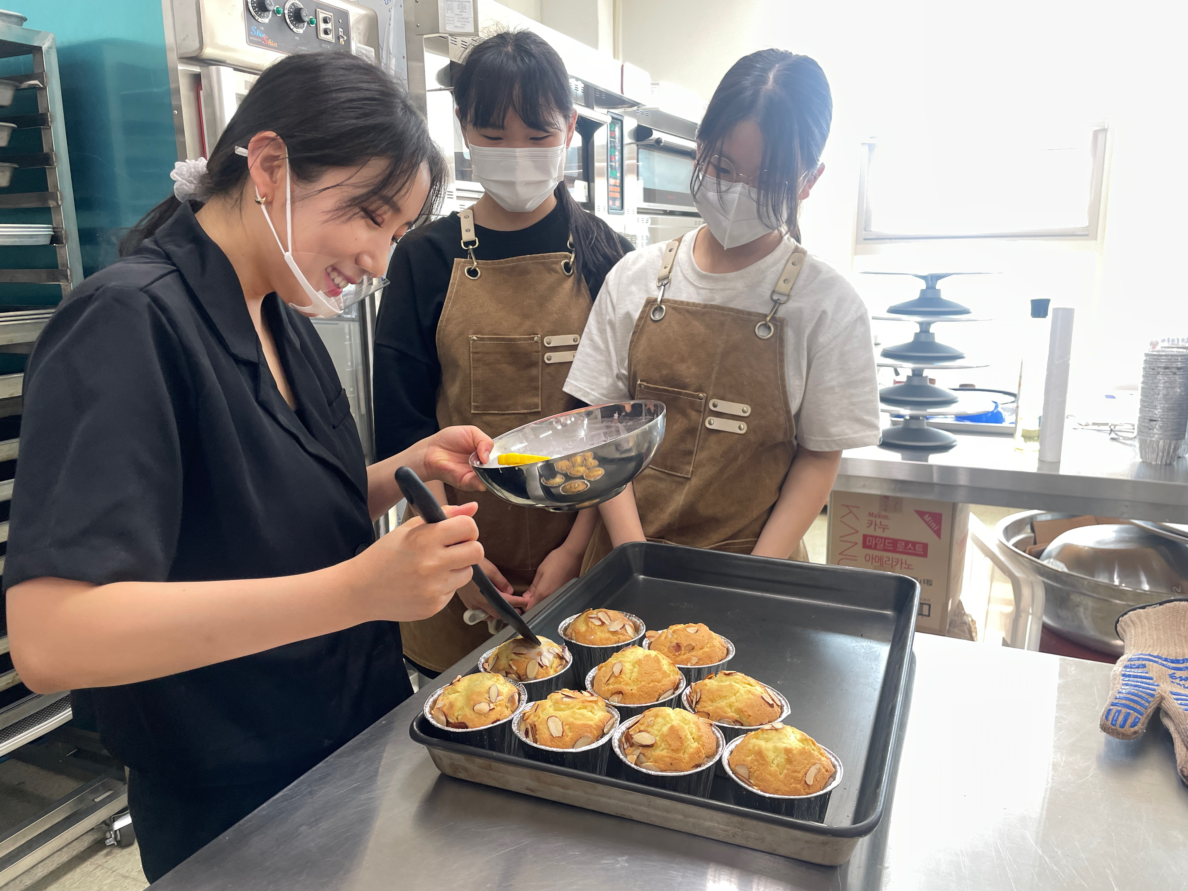 NOLSK artisan baking team preparing freshly baked financiers topped with sliced almonds
